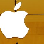 FILE PHOTO: Customers walk past an Apple logo inside of an Apple store at Grand Central Station in New York