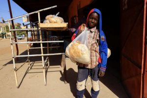 A boy carries a bag of bread in Khartoum